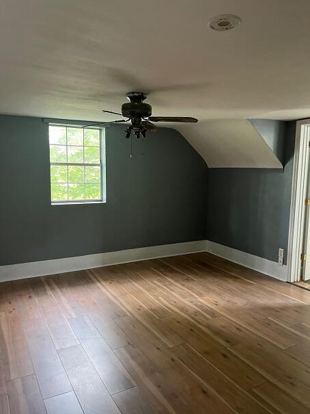 additional living space with wood-type flooring and ceiling fan