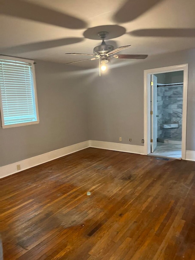 unfurnished room with ceiling fan and dark hardwood / wood-style flooring