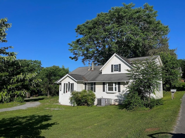 view of side of home with a lawn and cooling unit