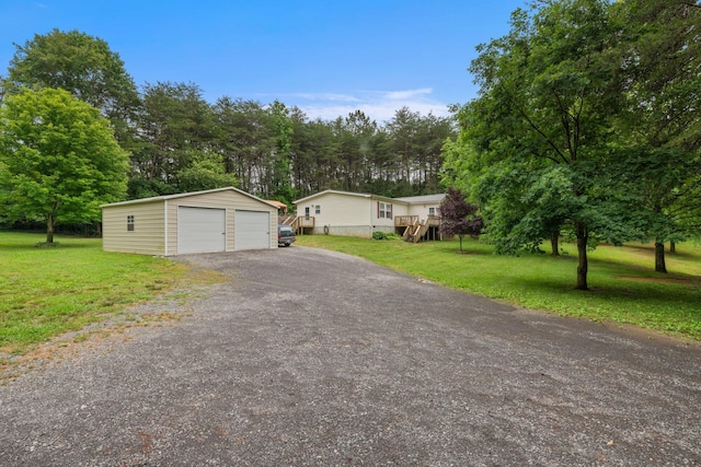 393 Friendship Ln, Delano, TN 37325 - manufactured / mobile home with an outdoor structure, a detached garage, a front lawn, and view of scattered trees