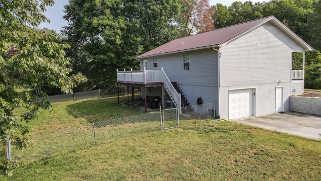 back of house featuring a garage, a yard, and a deck