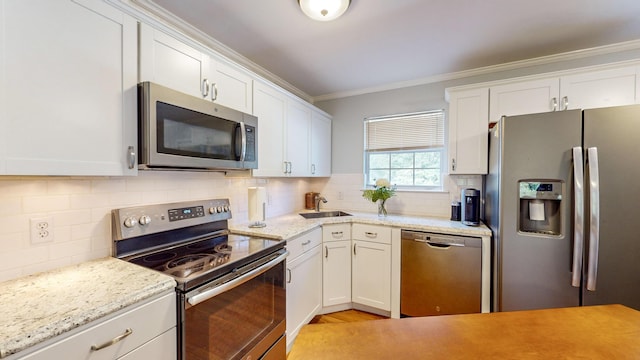 kitchen featuring ornamental molding, stainless steel appliances, and white cabinets