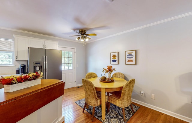 dining space featuring crown molding, a wealth of natural light, and light hardwood / wood-style floors