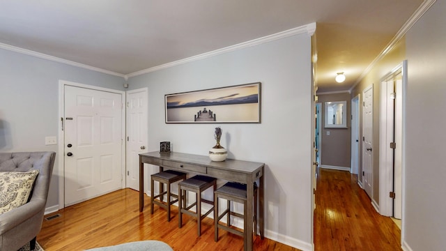 entrance foyer with crown molding and hardwood / wood-style floors