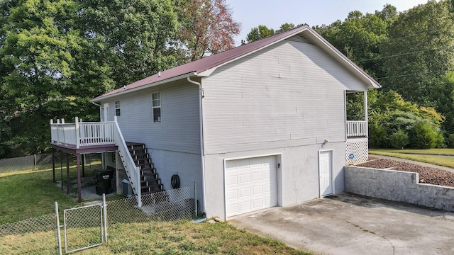 view of side of home with a garage, a lawn, and a deck