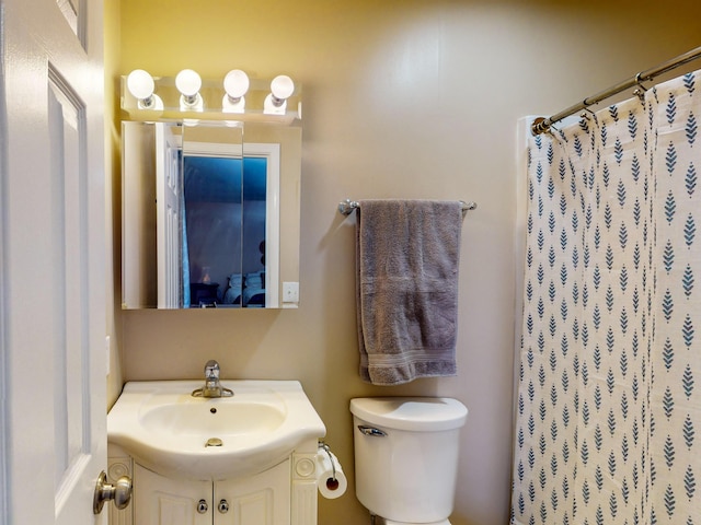 bathroom featuring vanity, toilet, and a shower with shower curtain