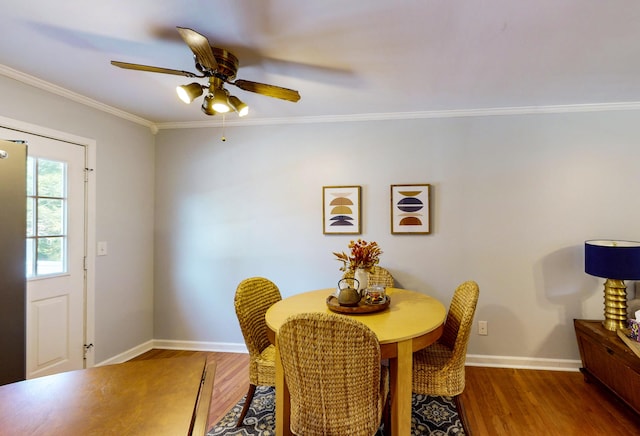 dining area featuring crown molding, dark wood-type flooring, and ceiling fan