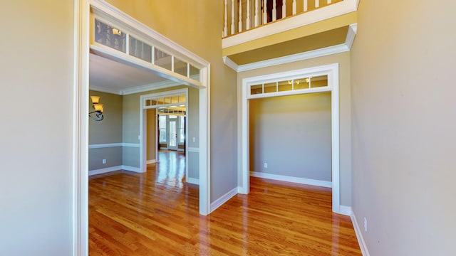 corridor featuring light hardwood / wood-style flooring and crown molding