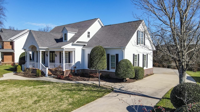 cape cod home featuring a porch and a front yard