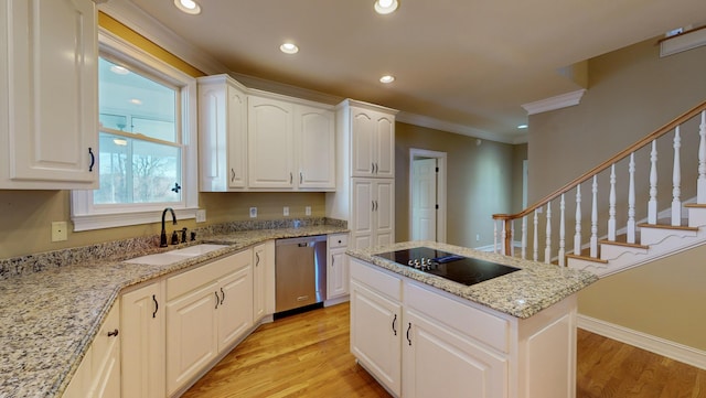 kitchen featuring white cabinetry, dishwasher, light stone countertops, and sink