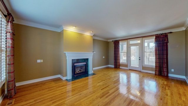 unfurnished living room with a fireplace, light wood-type flooring, and ornamental molding