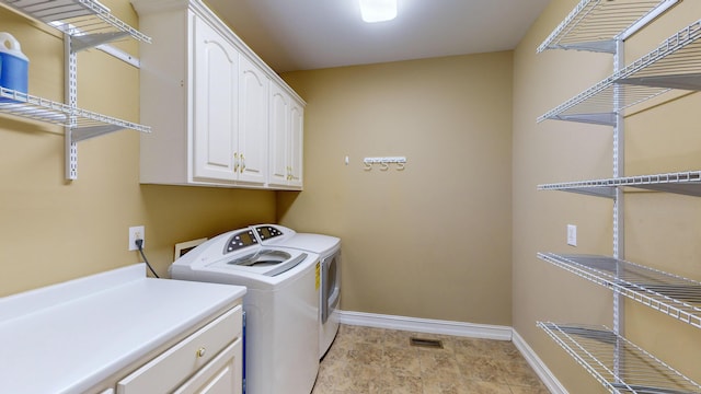 washroom featuring cabinets and washing machine and clothes dryer