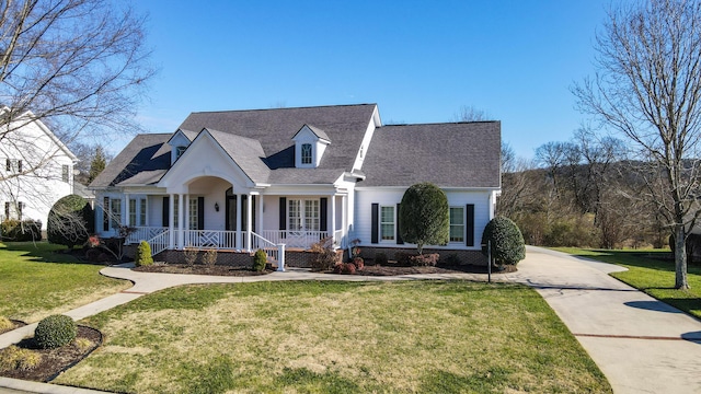 cape cod home with covered porch and a front lawn