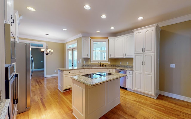 kitchen featuring sink, a kitchen island, decorative light fixtures, light hardwood / wood-style floors, and white cabinetry