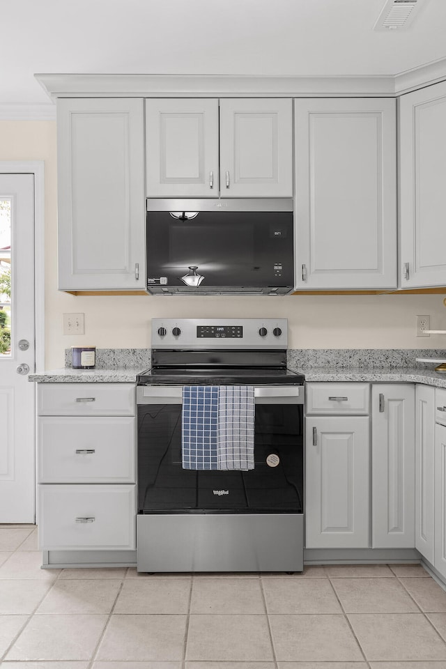 kitchen featuring light stone countertops, crown molding, light tile patterned floors, electric range, and white cabinetry