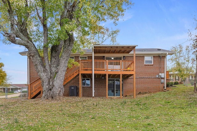 rear view of house with a deck and a lawn