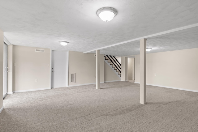 basement featuring a textured ceiling and carpet floors