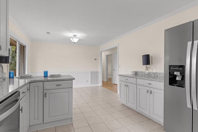 kitchen featuring kitchen peninsula, light stone counters, stainless steel appliances, crown molding, and white cabinets