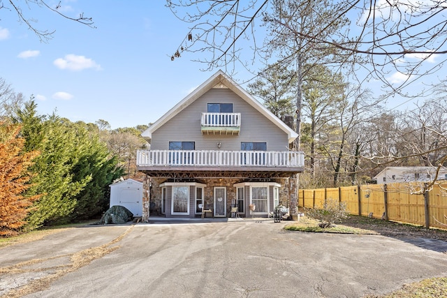 view of front of house with a shed, a balcony, and a porch