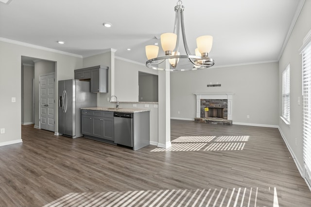 kitchen with gray cabinetry, hanging light fixtures, stainless steel appliances, and an inviting chandelier