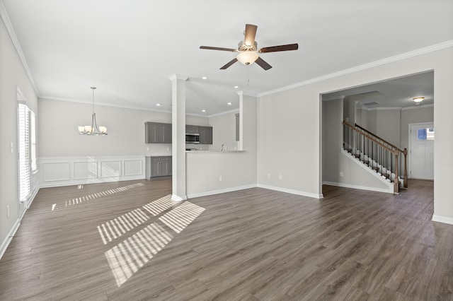 unfurnished living room with ceiling fan with notable chandelier, dark hardwood / wood-style flooring, and crown molding