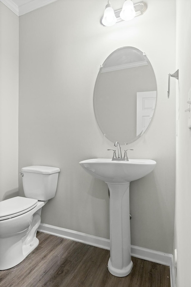 bathroom with toilet, wood-type flooring, and crown molding