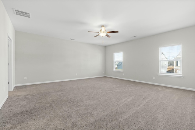 carpeted spare room featuring ceiling fan