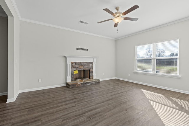 unfurnished living room featuring ceiling fan, dark hardwood / wood-style floors, a stone fireplace, and crown molding