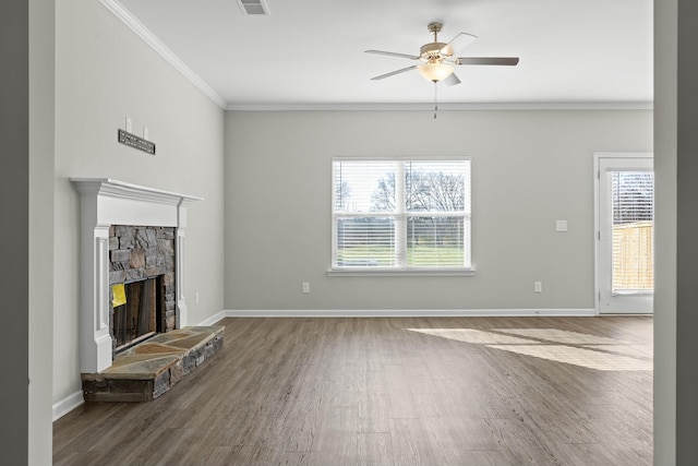 unfurnished living room with ceiling fan, a stone fireplace, wood-type flooring, and crown molding