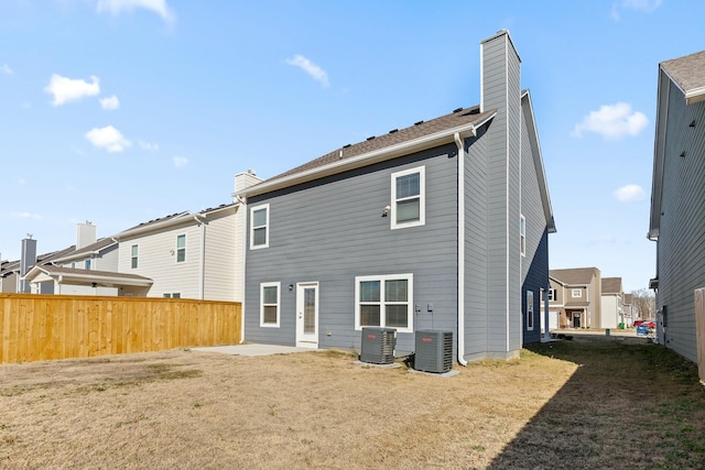 back of property with a lawn and central AC unit