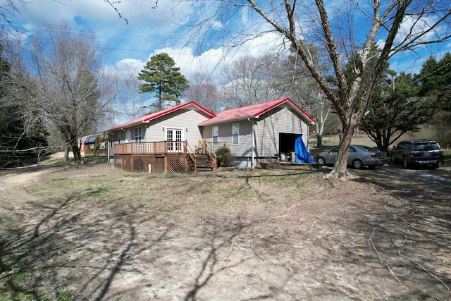 rear view of house featuring a wooden deck