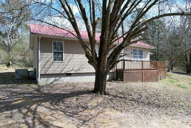 back of property with crawl space, central air condition unit, metal roof, and a wooden deck