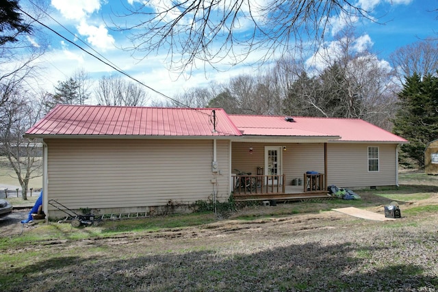 rear view of property featuring metal roof, crawl space, and a wooden deck