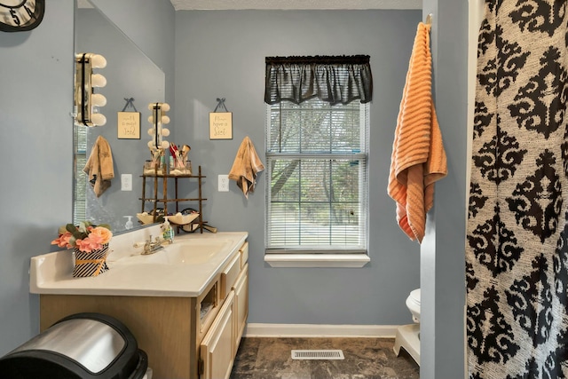 full bath featuring toilet, baseboards, visible vents, and vanity