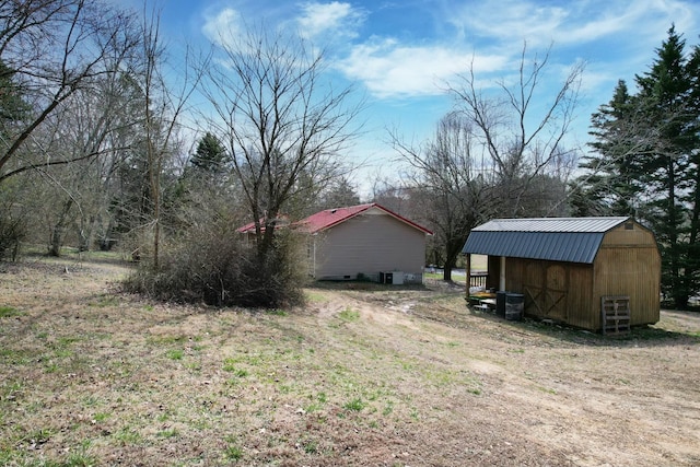 view of yard featuring central AC unit, a storage unit, and an outbuilding