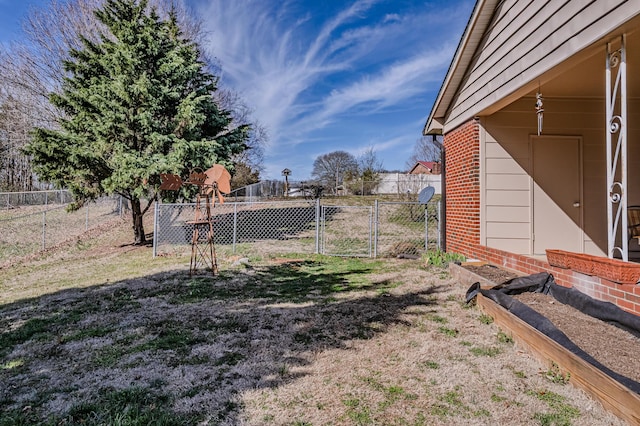 view of yard with a vegetable garden, a gate, and fence