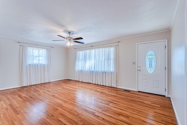 entryway with baseboards, visible vents, ceiling fan, crown molding, and light wood-type flooring