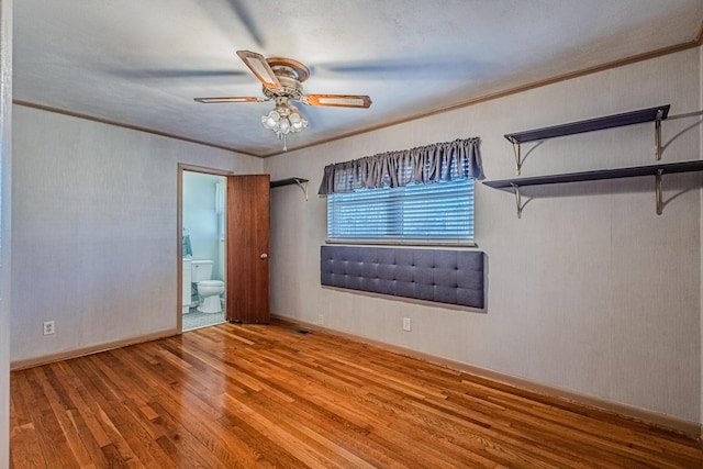 spare room with baseboards, crown molding, hardwood / wood-style floors, and ceiling fan