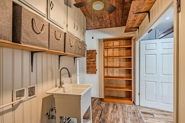 interior space featuring washer hookup, a ceiling fan, wood ceiling, wood finished floors, and laundry area