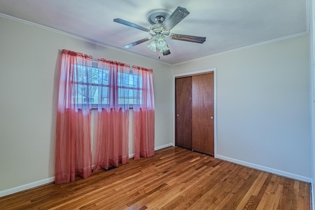 unfurnished bedroom with ornamental molding, baseboards, and wood finished floors