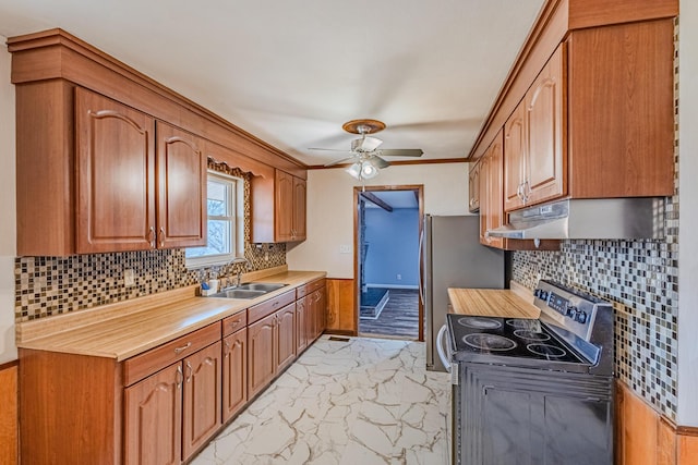 kitchen featuring marble finish floor, light countertops, appliances with stainless steel finishes, a sink, and under cabinet range hood