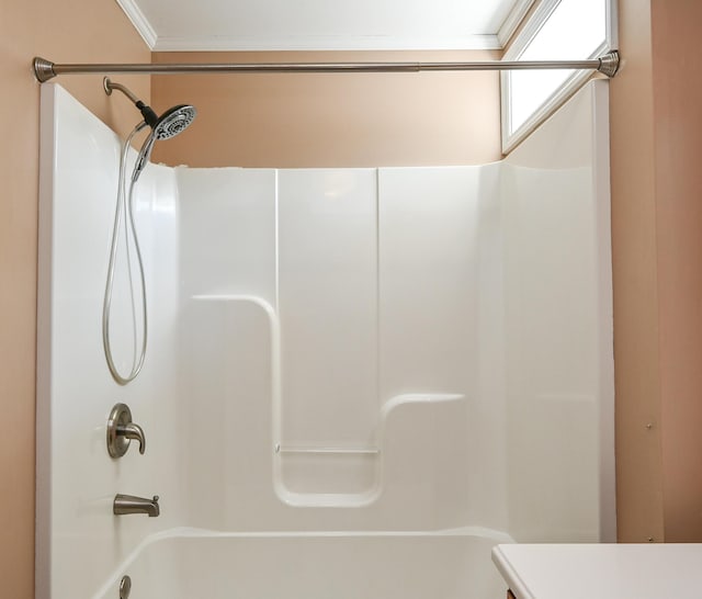 bathroom with ornamental molding and shower / bath combination