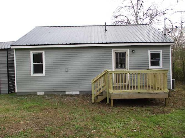 rear view of house with a yard and a wooden deck