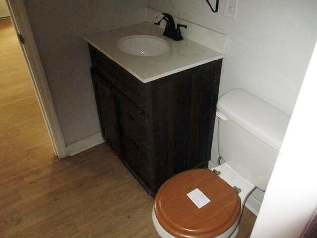 bathroom featuring hardwood / wood-style flooring, vanity, and toilet