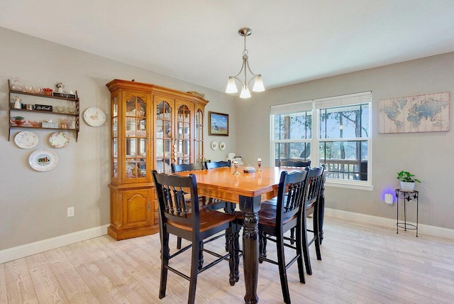 dining area featuring light hardwood / wood-style floors and a notable chandelier