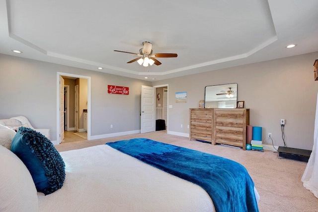 bedroom with ensuite bathroom, ceiling fan, carpet, and a raised ceiling