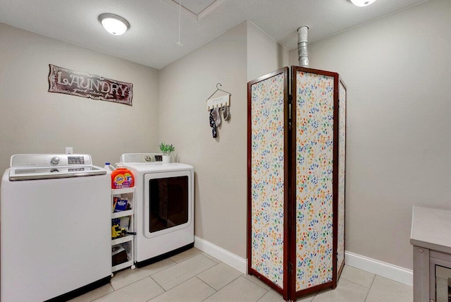 laundry area with light tile patterned flooring and washing machine and clothes dryer