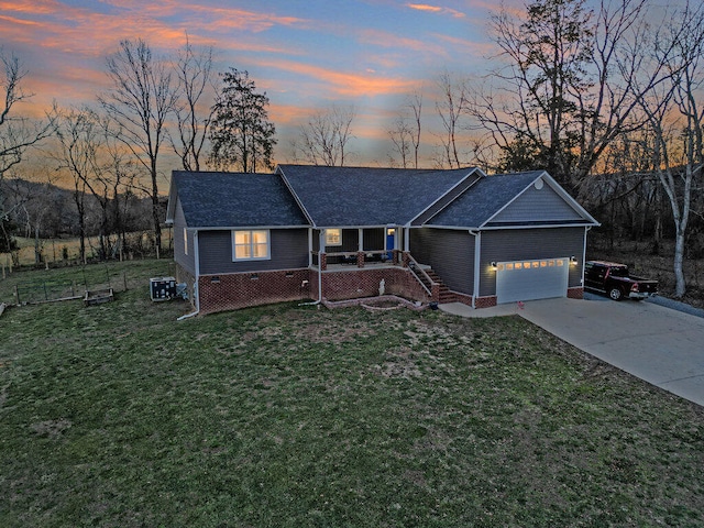 ranch-style house featuring an attached garage, cooling unit, a lawn, and concrete driveway