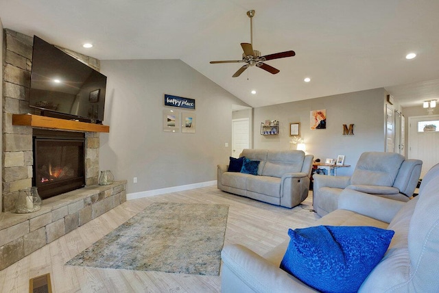 living room with ceiling fan, vaulted ceiling, light hardwood / wood-style flooring, and a fireplace