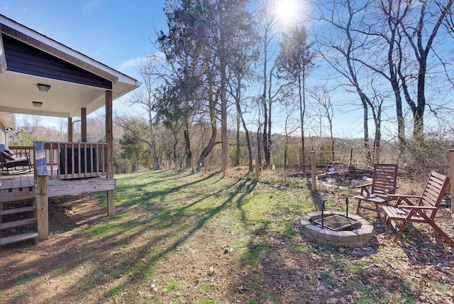 view of yard featuring a wooden deck and an outdoor fire pit